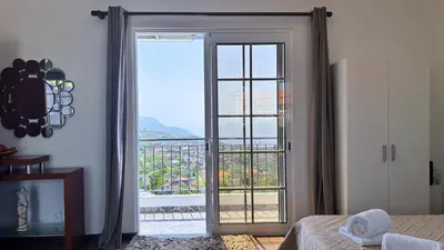 a bedroom with a door open to a balcony at Golden Horizon House By Sam Houses in Ponta do Sol