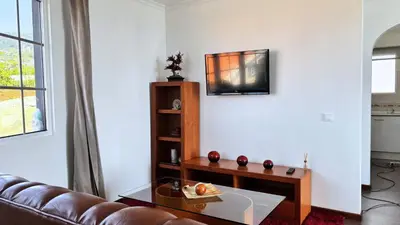 a living room with a couch and a table at Golden Horizon House By Sam Houses in Ponta do Sol