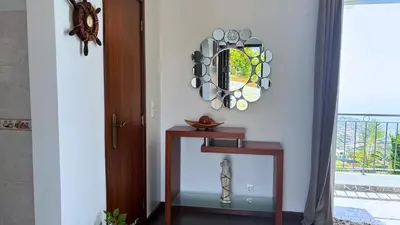a room with a table and a mirror and a window at Golden Horizon House By Sam Houses in Ponta do Sol