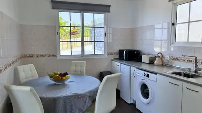 a kitchen with a table with a bowl of fruit on it at Golden Horizon House By Sam Houses in Ponta do Sol