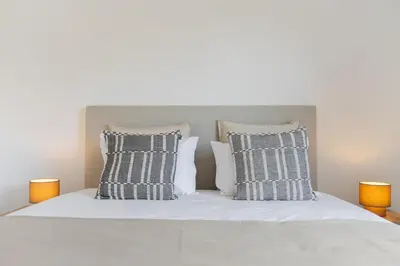 a white bed with four pillows on it at Apartamento Ajuda-Madeira by An Island Apart in Funchal