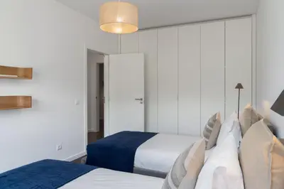 a bedroom with two beds and a large mirror at Apartamento Ajuda-Madeira by An Island Apart in Funchal