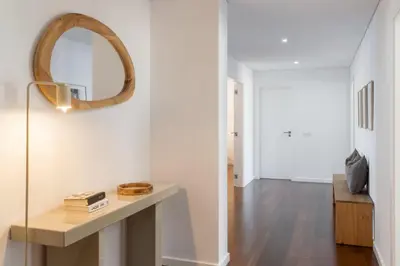 a living room with a table and a mirror at Apartamento Ajuda-Madeira by An Island Apart in Funchal