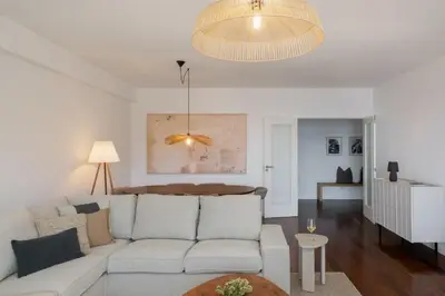 a living room with a white couch and a chandelier at Apartamento Ajuda-Madeira by An Island Apart in Funchal