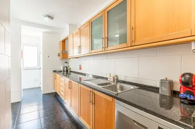 a kitchen with wooden cabinets and a sink at Amethyst Scape Caniço Madeira by GRM in Caniço