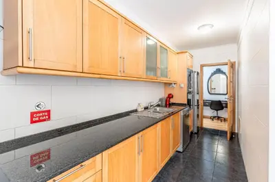 a kitchen with wooden cabinets and a sink at Amethyst Scape Caniço Madeira by GRM in Caniço