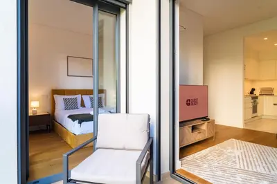 a bedroom with a bed and a sliding glass door at GuestReady - Acqua residences in Funchal