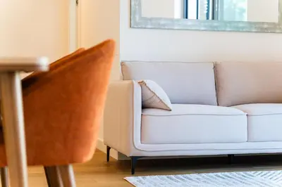 a white couch in a living room with a mirror at GuestReady - Acqua residences in Funchal