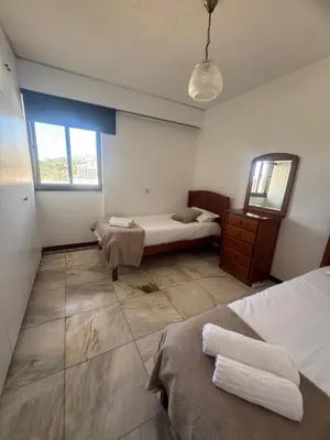 a bedroom with two beds and a mirror in it at My Sun Holidays in Funchal