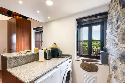 a kitchen with a washer and dryer at Casinha do Mar by GALMI in São Vicente