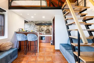 a staircase leading to the kitchen and living room of a tiny house at Casinha do Mar by GALMI in São Vicente