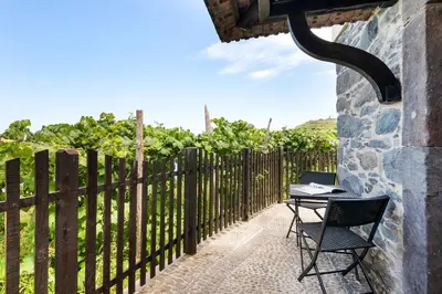 a table and chairs on a patio next to a fence at Casinha do Mar by GALMI in São Vicente