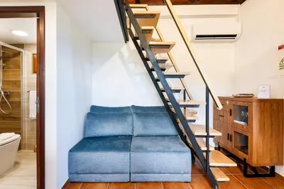a staircase in a bathroom with a blue couch at Casinha do Mar by GALMI in São Vicente