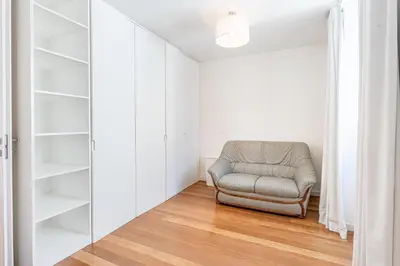 a gray chair in a room with white shelves at Port and Stone Villa in Funchal