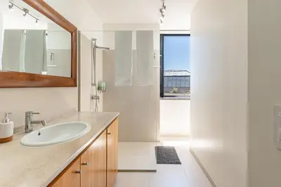 a white bathroom with a sink and a mirror at Port and Stone Villa in Funchal