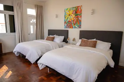 two beds with white sheets in a room at Casa Branca do Monte in Funchal
