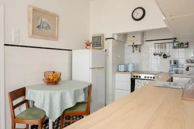 a kitchen with a table and a white refrigerator at Casa Branca do Monte in Funchal