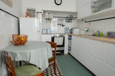 a kitchen with a table and a white refrigerator at Casa Branca do Monte in Funchal