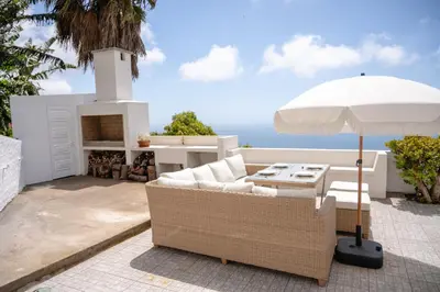 a living room with a couch and an umbrella at Casa Branca do Monte in Funchal