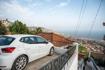 a white car parked on a balcony overlooking the city at Casa Branca do Monte in Funchal