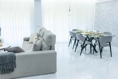 a living room with a couch and a table with chairs at MCM Matur Flats 2, 11 Duplex in Santa Cruz