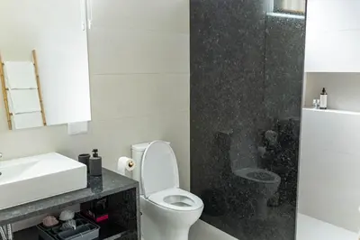 a bathroom with a white toilet and a sink at MCM Matur Flats 2, 11 Duplex in Santa Cruz