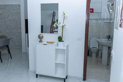 a white bathroom with a toilet and a sink at MCM Matur Flats 2, 11 Duplex in Santa Cruz
