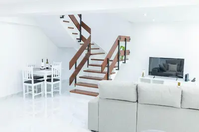 a living room with a couch and a staircase at MCM Matur Flats 2, 11 Duplex in Santa Cruz