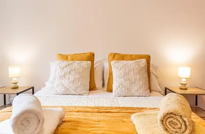a bedroom with a bed and a yellow chair at Casa Nobrega in Caniço