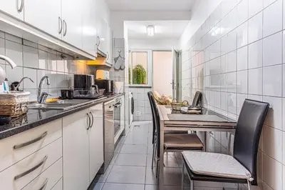 a kitchen with a refrigerator and a table in it at Casa Nobrega in Caniço