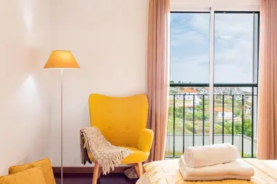 a bedroom with a bed and a large window at Casa Nobrega in Caniço