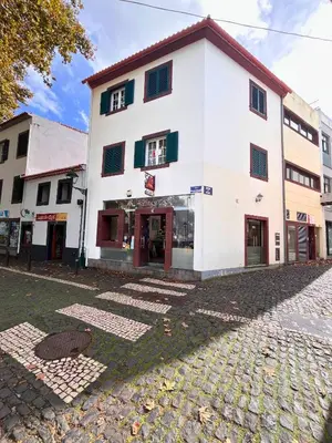 a white building on a cobblestone street at Machico Village Apartment - Terrace and private parking in Machico