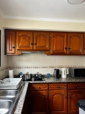 a living room with a tv and a white table at Machico Village Apartment - Terrace and private parking in Machico