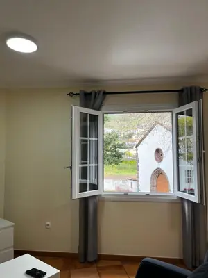 a small white church with a view of a city at Machico Village Apartment - Terrace and private parking in Machico