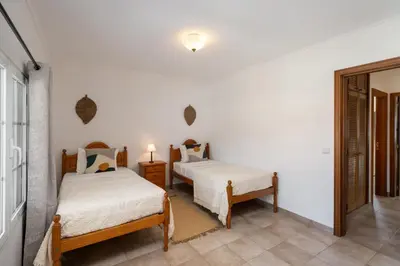a bedroom with two beds and a mirror at Apartamento da Vila by An Island Apart in Porto Santo