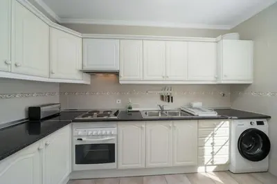 a white kitchen with a sink and a dishwasher at Apartamento da Vila by An Island Apart in Porto Santo