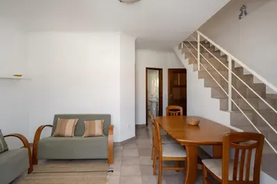 a living room with a dining room table and a staircase at Apartamento da Vila by An Island Apart in Porto Santo