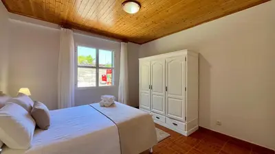 a bedroom with a white bed and a window at Domingos Reis in São Vicente
