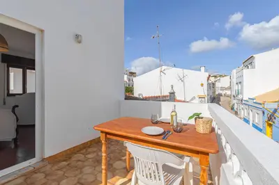 a balcony with a couch and a view of the ocean at Blue House Burgau in Burgau