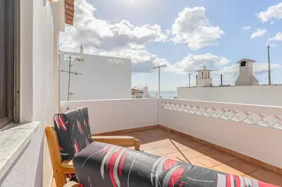 a balcony with two chairs and a table and a bedroom at Blue House Burgau in Burgau
