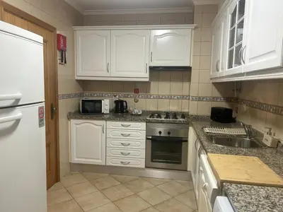 a kitchen with white cabinets and a stove top oven at Porto Santo Rentals in Porto Santo