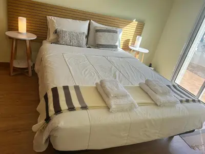 a large white bed with two pillows on it at Porto Santo Rentals in Porto Santo