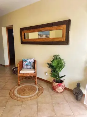 a room with a chair and a mirror and a plant at Porto Santo Rentals in Porto Santo