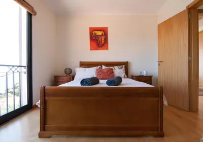 a bedroom with a bed with blue pillows on it at Casa Nici in Calheta