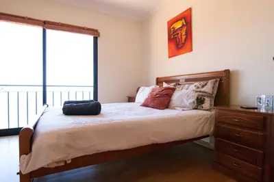 a bedroom with a bed with a large window at Casa Nici in Calheta