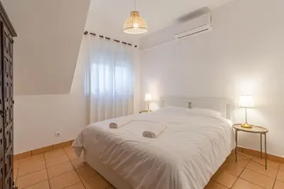 a bedroom with a white bed and two lamps at Casa da Praia Burgau in Burgau