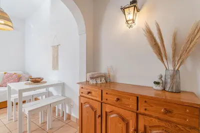a dining room with a table and a wooden dresser at Casa da Praia Burgau in Burgau