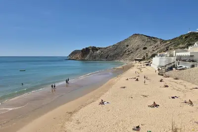 a group of people on a beach next to the ocean at Casa da Praia Burgau in Burgau