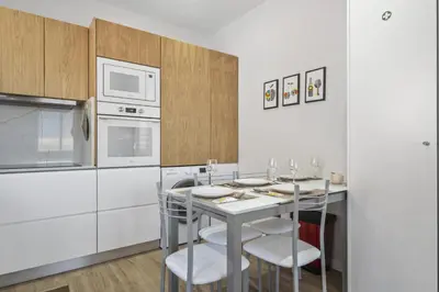 a kitchen with a table with chairs and a microwave at Orinoco Sunset House I - Private Jacuzzi in Calheta