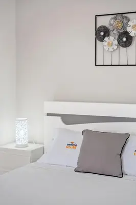 a white bedroom with a bed and a picture on the wall at Orinoco Sunset House I - Private Jacuzzi in Calheta